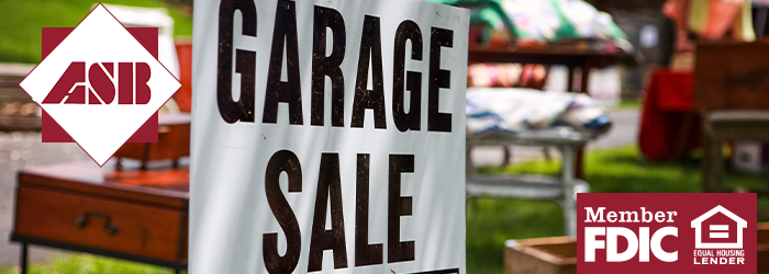 Garage Sale sign zoomed in on with garage sale items in the background blurred