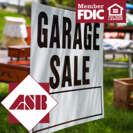 Garage Sale sign zoomed in on with garage sale items in the background blurred