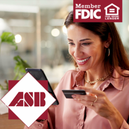 Woman smiling at her smartphone while holding her debit card in her other hand