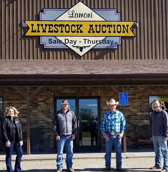 owners standing in front of Lamoni Livestock building front